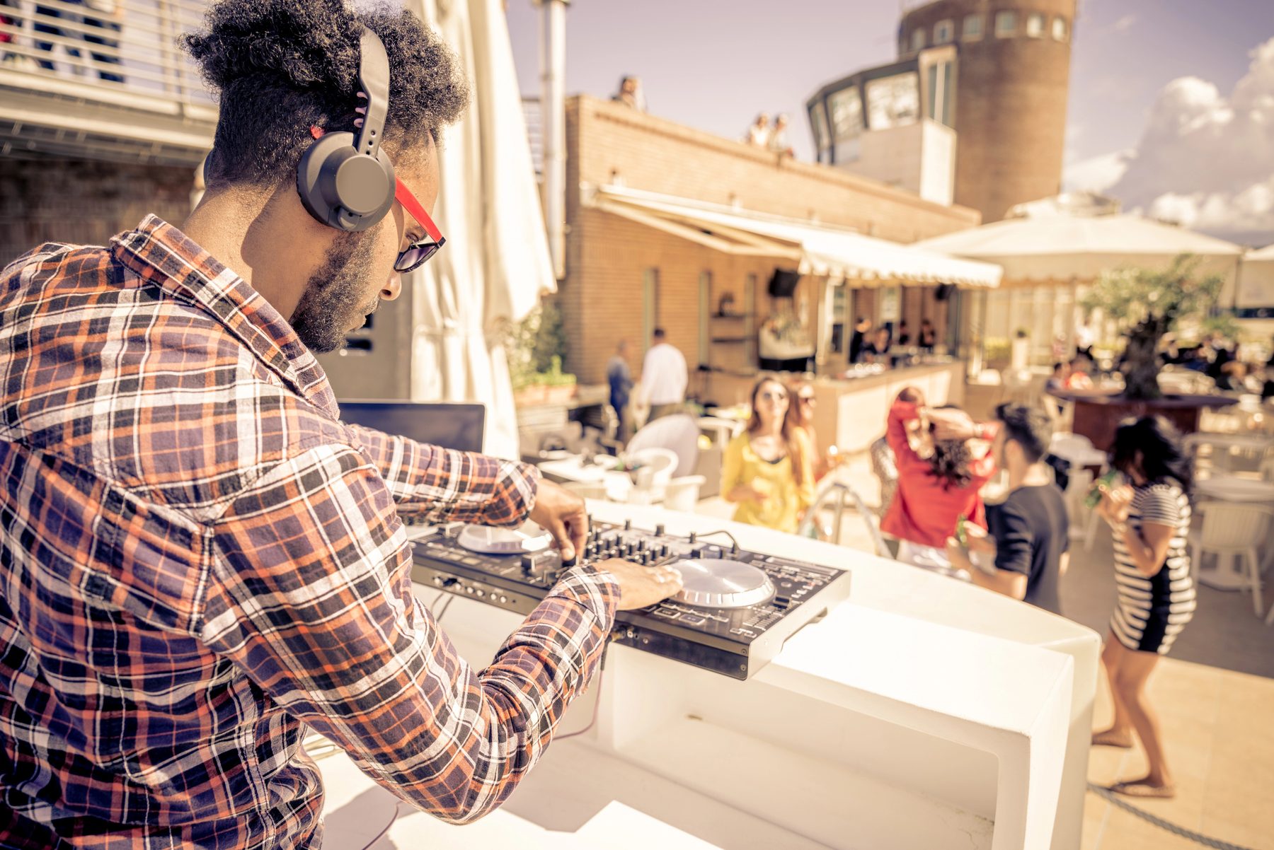A creator mixing at a daytime block party